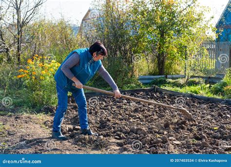 een peuter die met kindertuingereedschap in de tuin werkt