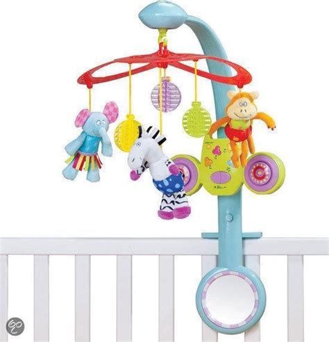 Een baby die vanuit de box naar een kleurrijke muziekmobiel kijkt.