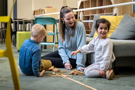 Illustratie van een pedagogisch medewerker die een activiteit met jonge kinderen begeleidt.