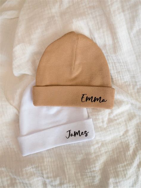 Een schattige baby met een gepersonaliseerd mutsje met naam