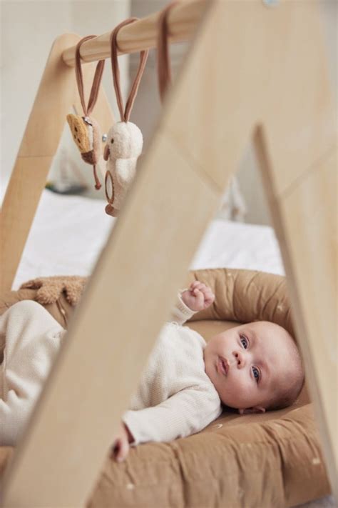 Een houten babygym van Jollein met diverse hangende speeltjes