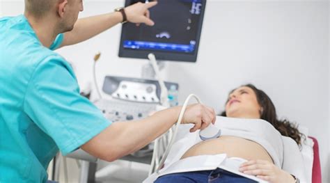 Gynaecoloog voert een echografie uit bij een patiënt.