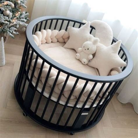 Een stijlvolle, zwarte ronde babybox met beige accessoires.