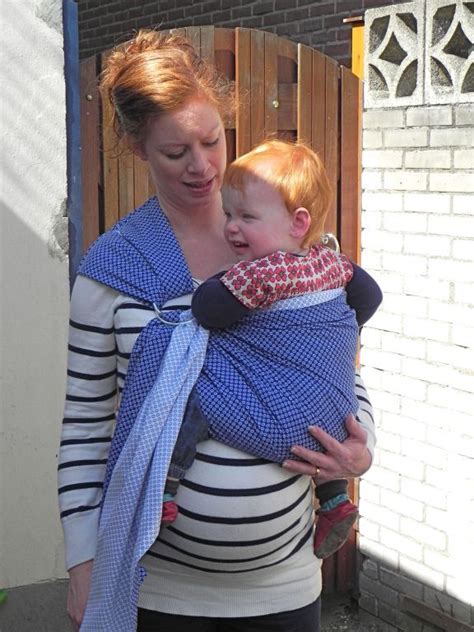 Illustratie van een ouder die een baby in een ringsling op de heup draagt