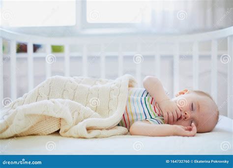 Foto van een baby in een side-bedje, duidelijk bevestigd aan het ouderlijk bed