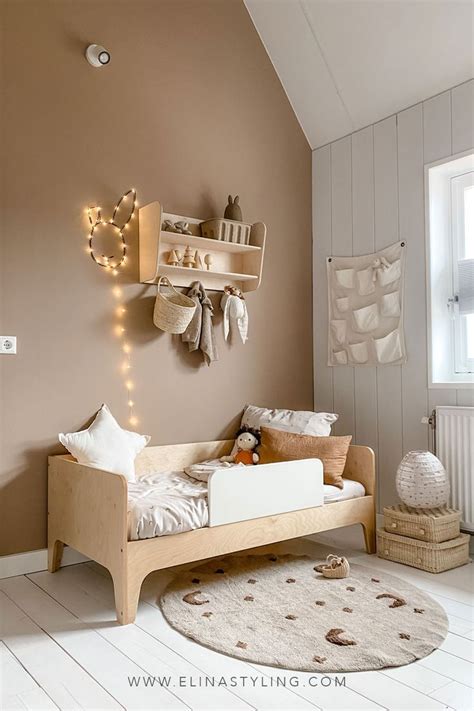 Foto van een kinderkamer met diverse houten Janbibejan items, zoals een kastje met elfjes en een kapstok.