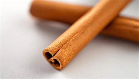 Illustratie van kaneelstokjes en gemalen kaneel met een waarschuwingsteken.