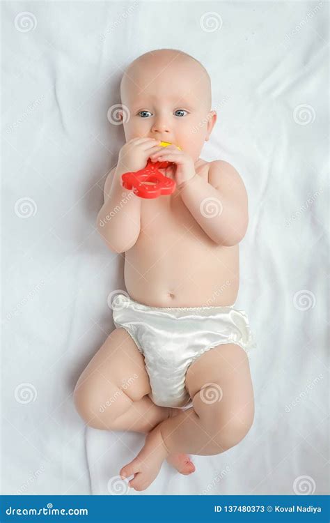 baby zonder luier die speelt op een kleedje