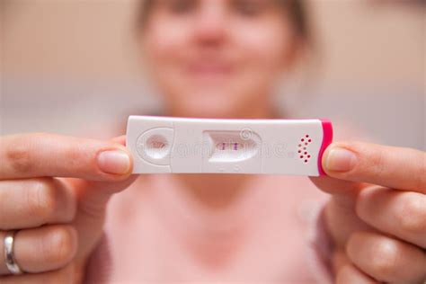 vrouw houdt positieve zwangerschapstest vast