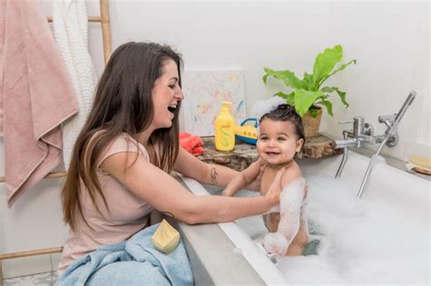 Afbeelding van een baby die zachtjes in een badje wordt geholpen