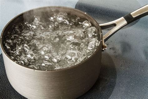 Illustratie van een pan met kokend water waarin een fopspeen wordt gesteriliseerd.