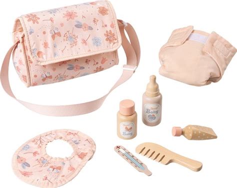 Set van poppenverzorgingsaccessoires, waaronder een luiertas, speenfles, kam, en een poppendrager.