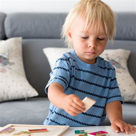 Illustratie van een baby en peuter met symbolische elementen die wijzen op autisme, zoals een kind dat wegkijkt van een ouder of geconcentreerd is op een enkel object.