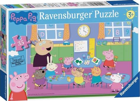 Een kind van ongeveer 2 jaar zit geconcentreerd een Peppa Pig legpuzzel te maken