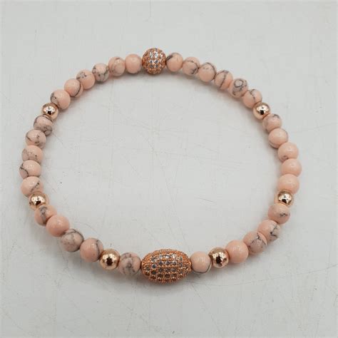 Vrouwen die edelsteen armbanden vasthouden, symboliserend verbinding en welzijn tijdens de zwangerschap.