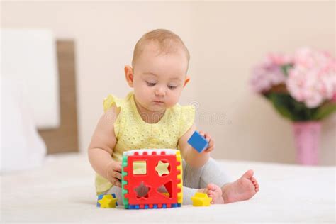 een vrolijke baby die speelt met een zacht pluchen VTech speeltje