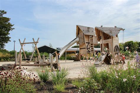 een rustige visvijver met picknicktafels en een speeltuin op de achtergrond