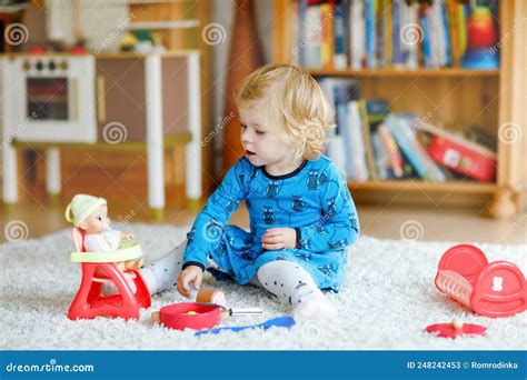 Foto van een kind dat vrolijk speelt in een schelpvormige zandbak met een blauwe deksel.