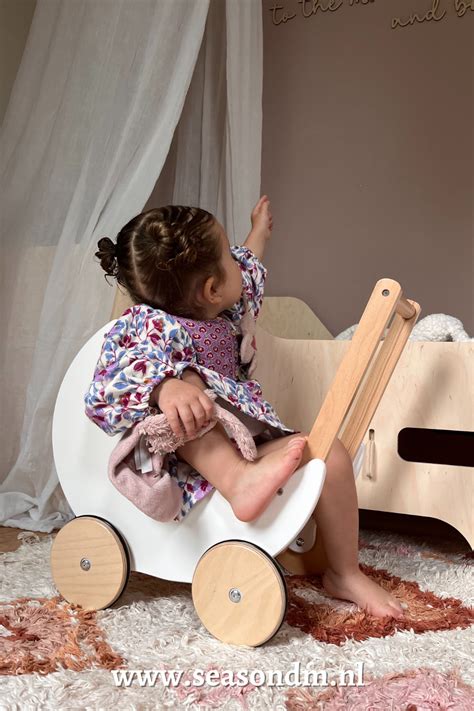 Een kind dat met een poppenwagen speelt, waarbij de nadruk ligt op zorgzaamheid en verbeelding.