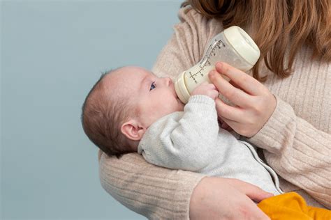 baby drinkt uit een fles naast een vrouw die borstvoeding geeft