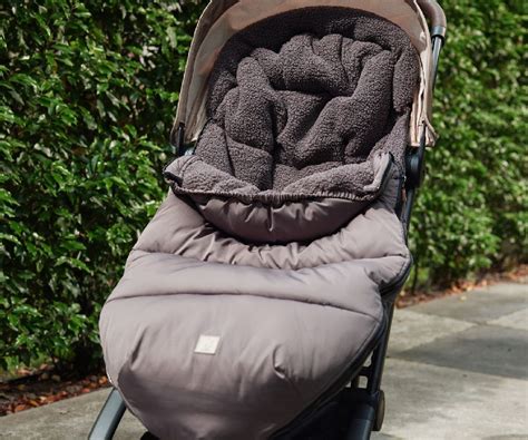 Illustratie van Jollein voetenzak en zonnekap in gebruik op een autostoeltje