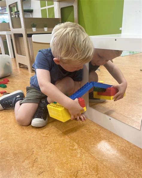 Foto van een kind dat trots zijn eerste DUPLO bouwwerk laat zien.