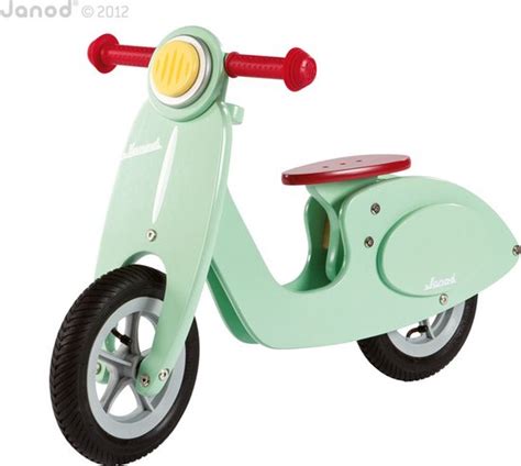 Illustratie van diverse Janod houten speelgoedproducten: stapeltoren, loopfiets, muziekinstrument.