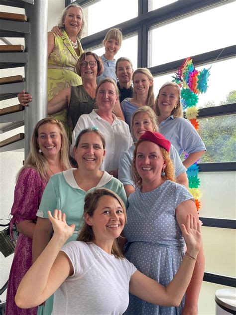 Foto van een team kraamverzorgsters en verloskundigen tijdens een gezamenlijke bijeenkomst.