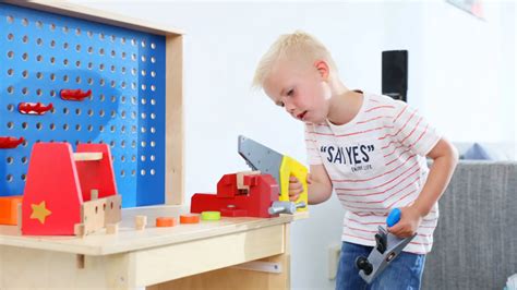 kind dat met gereedschap speelt aan de Chicco werkbank