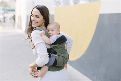 Diverse Ergobaby draagzakken in verschillende kleuren en modellen, tentoongesteld op een neutrale achtergrond.