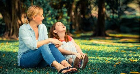 Foto van een ouder die een ouder kind op de rug draagt tijdens een wandeling in de natuur