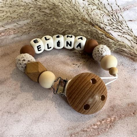 Illustratie van een speenkoord dat aan kleding is bevestigd.