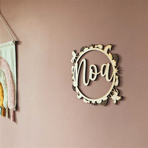 Een houten naamcirkel met de naam van de baby, passend bij diverse interieurs.
