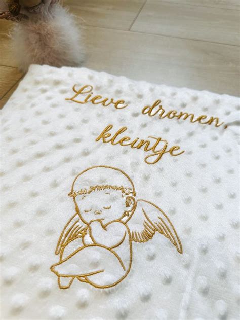 Een voorbeeld van een gepersonaliseerde babydeken met naam en een schattig ontwerp.
