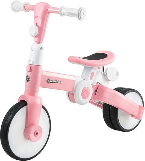 Baby met een loopfietsje in een woonkamer