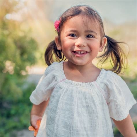 Een peuter die vrolijk rondhobbelt op een springkoe in de tuin.