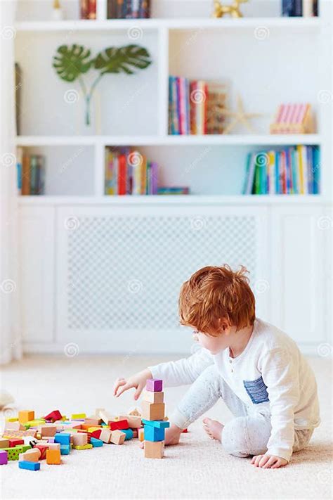 Een kind dat met houten blokken een hoge toren bouwt