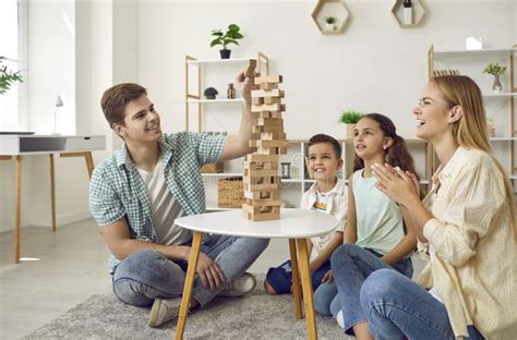 Gegroepeerde ouders en kinderen die samen spelen in een kindvriendelijke ruimte binnen een Huis van het Kind