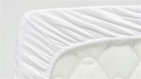 Visuele vergelijking van de lagen in een opgemaakt babybed: matras, molton, hoeslaken, en eventueel een topper of bedzeiltje.