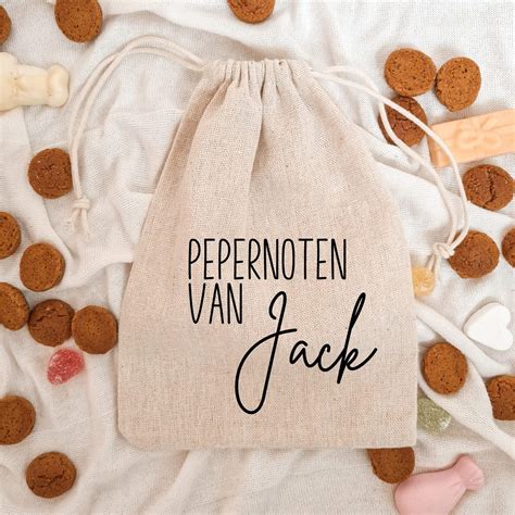 Kinderen leggen de eerste letter van hun naam met pepernoten