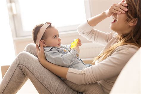 baby speelt kiekeboe achter een doek
