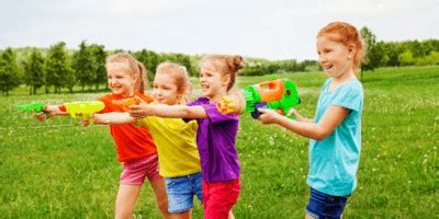 Kinderen spelen met waterpistolen en opblaasbare zwembaden