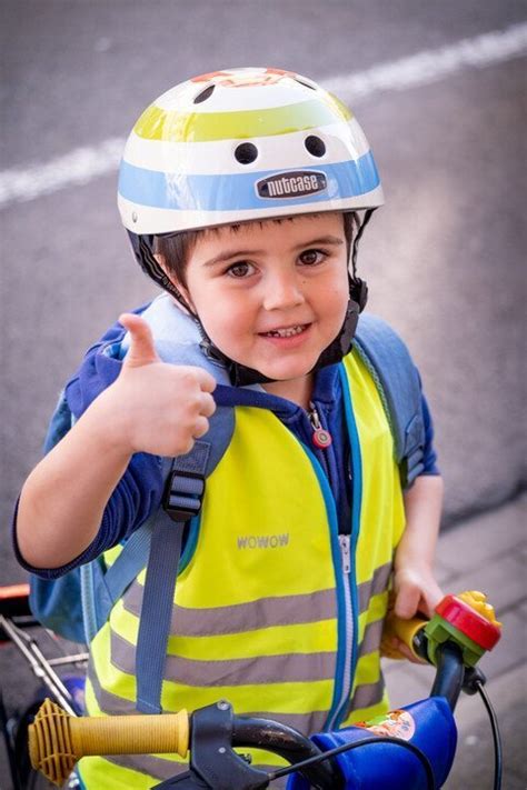 Een kind met een helm, pols- en elleboogbeschermers die voorzichtig op rolschaatsen staat.