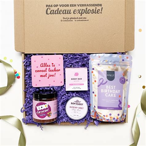 Een sfeervolle foto van een cadeaubox gevuld met luxe verzorgingsproducten en een zachte deken.