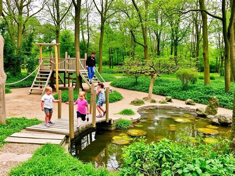 Kinderen spelen enthousiast in een grote natuurspeeltuin.