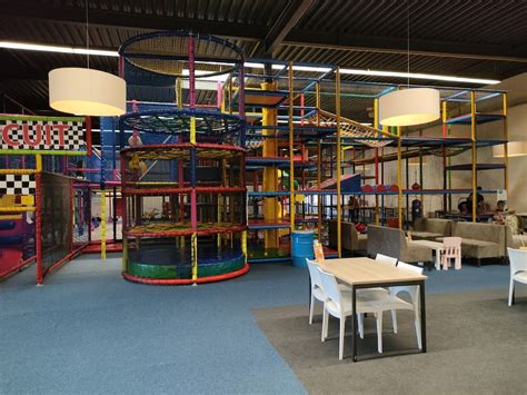 Kinderen spelen enthousiast in een grote indoor speeltuin van Ballorig.