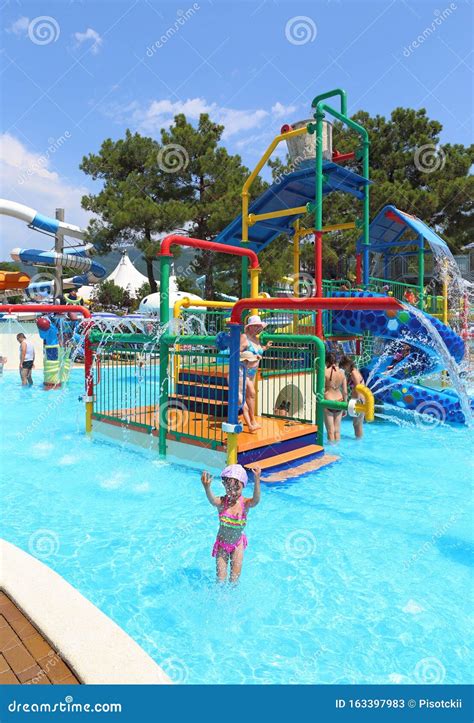 Kinderen zwemmen en spelen in een waterpark.
