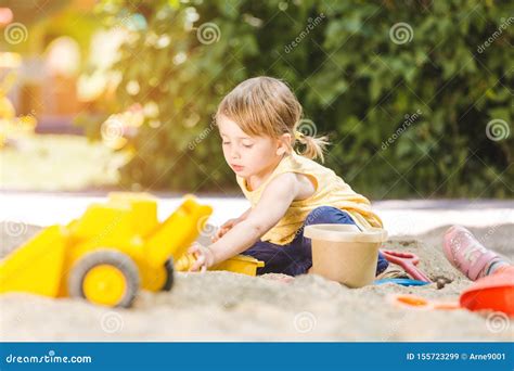een kind dat met plezier met zand speelt in een zandbak