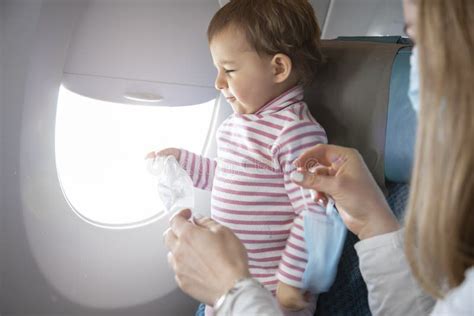 Een baby die met plezier uit een knijpzakje eet in een vliegtuigstoel.