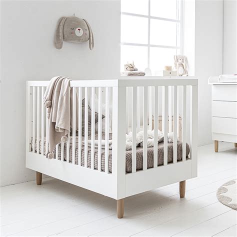 Een baby ledikant met een gestreept hoeslaken